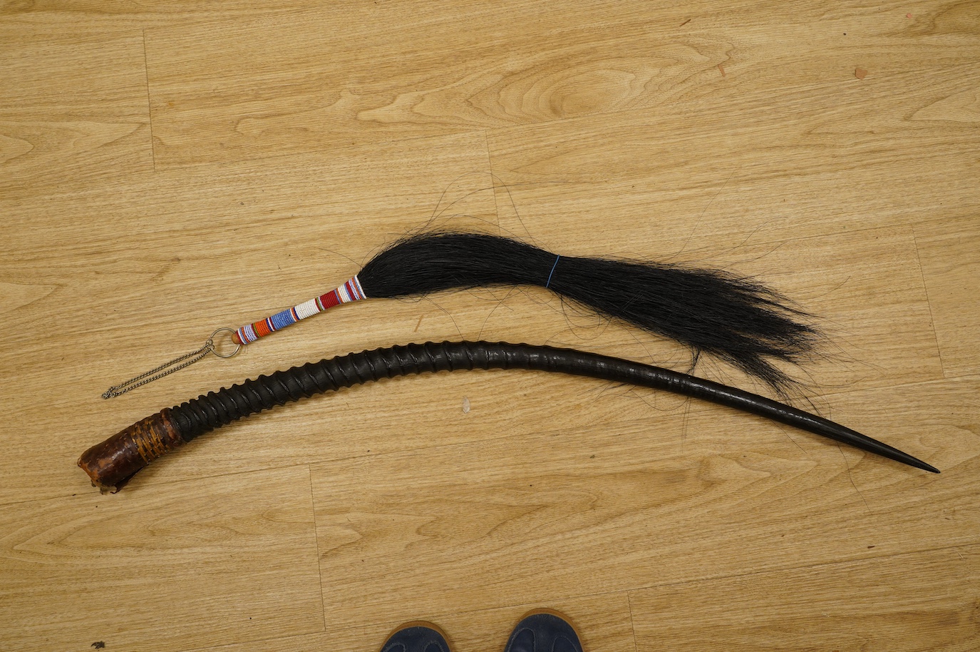 An African antelope horn, 92cm long, and a fly whisk. Condition - fair to good